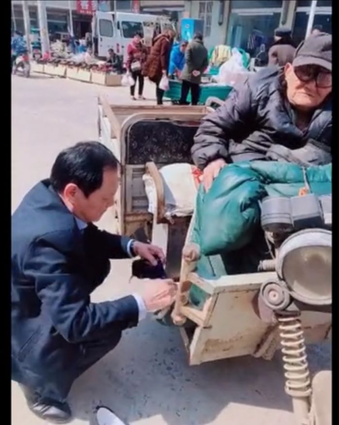盧書林在給老人穿鞋襪。（視頻截圖）
