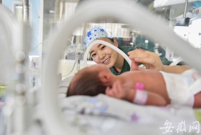 0 護士江為在和保溫箱里的孩子交流，這里的孩子們不允許家長陪伴，護士便是孩子們的“臨時媽媽”，直到孩子被治愈出院 (1)