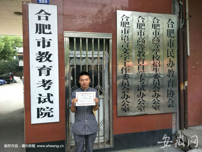 昨日上午在拿到安徽大學法學專業自考本科證書后，齊永章在合肥市教育考試院門口留影。
